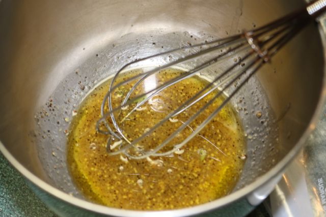 In a small bowl, whisk together the olive oil, vinegar, lemon juice, sugar, garlic, mustard, salt and pepper
