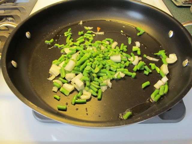 Saute onion and garlic scapes.