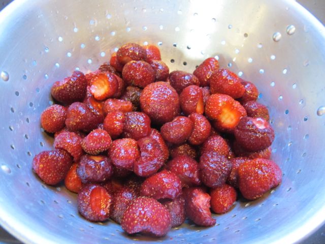 Remove stems and leaves from strawberries.
